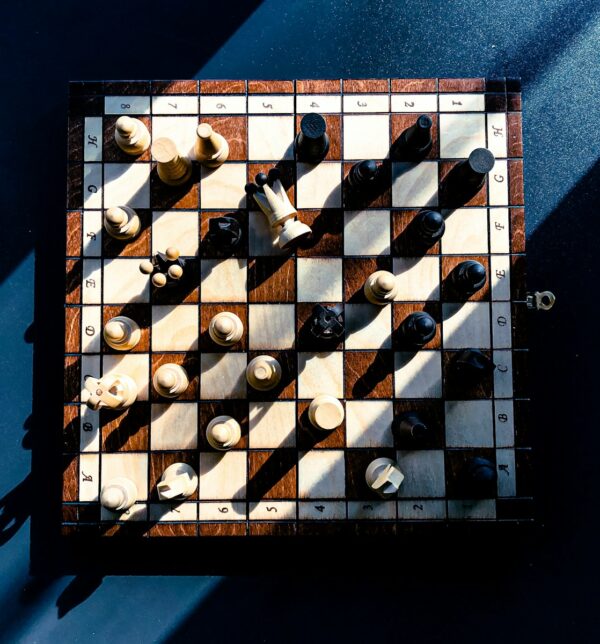 A wooden chess board with white and black pieces